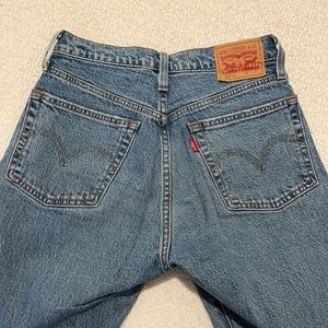 MEDIUM WASH LEVI 501’s WITH ONE KNEE HOLE AND FRAYED BOTTOMS